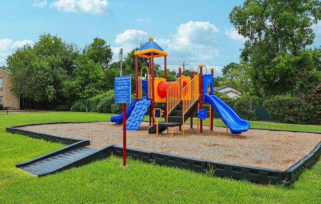 A playground with a blue slide and a yellow slide.