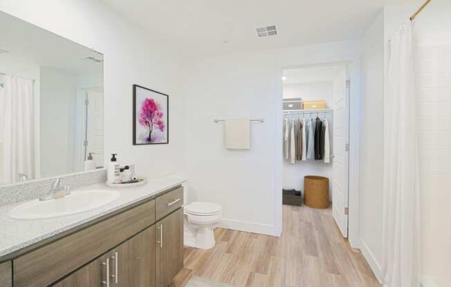 a bathroom with white walls and wood floors