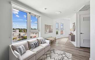 A living room with a couch and a large window.