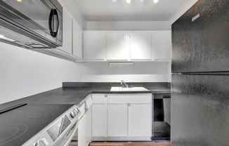 a kitchen with white cabinets and stainless steel appliances