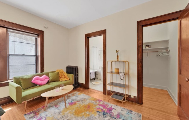 a living room with a green couch and a rug