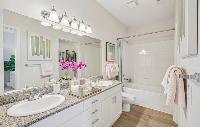 A bathroom with a white sink and a white toilet.