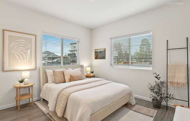A bedroom with a large bed, a wooden nightstand, and a framed picture on the wall.