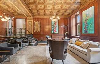 a living room with wood paneling and a seating area with a table and chairs