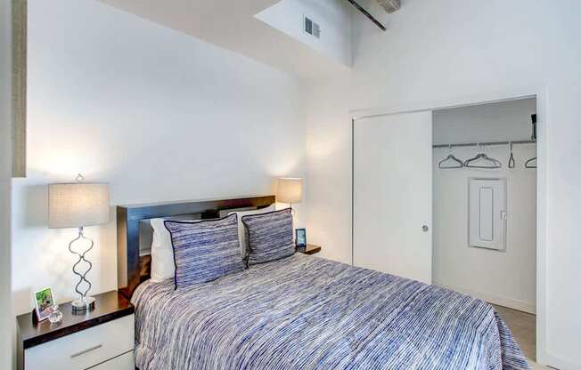 A bedroom with a bed, nightstand, and two lamps.