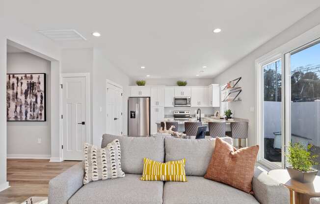 a living room with a couch and a kitchen in the background in a home at Sanctuary at Indian Creek