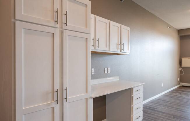 a desk with white cabinets and a wood floor. Fargo, ND 29 West Apartments