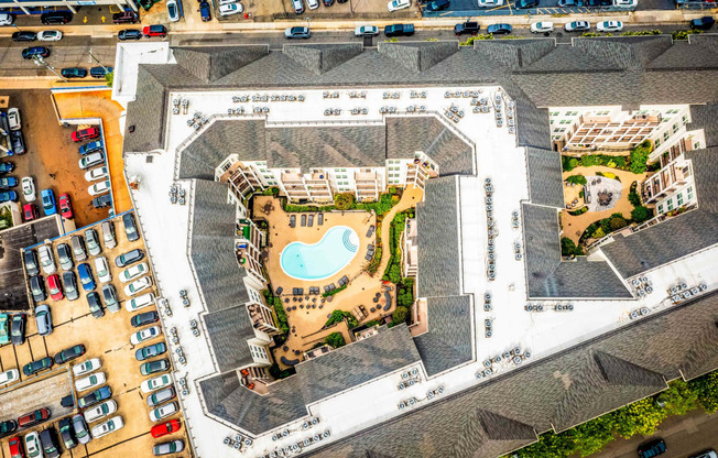 an aerial view of a building with a pool and parking lot at Metro 303, Hempstead, NY