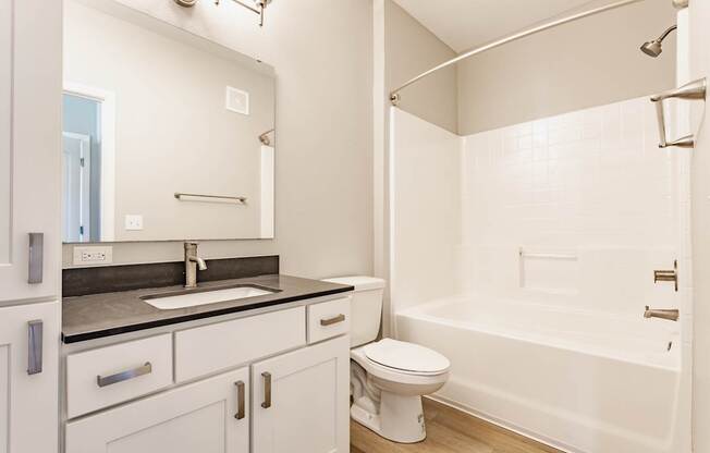A white bathroom with a sink, toilet, and bathtub.