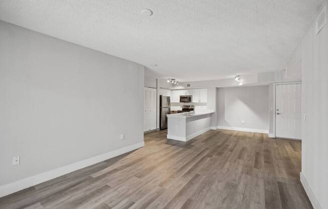A room with wooden flooring and white walls.