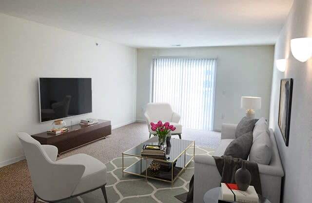 a living room with white furniture and a television