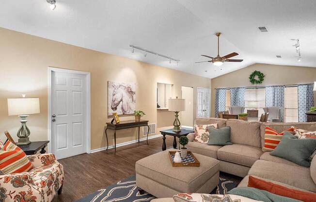 a living room filled with furniture and a ceiling fan