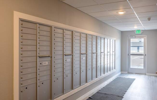 a row of lockers in a hallway with an exit door
