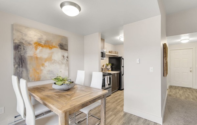 a dining room with a wooden table and white chairs