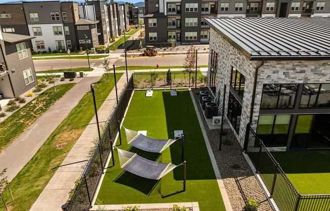 A small grassy area with a table and chairs is surrounded by a fence.