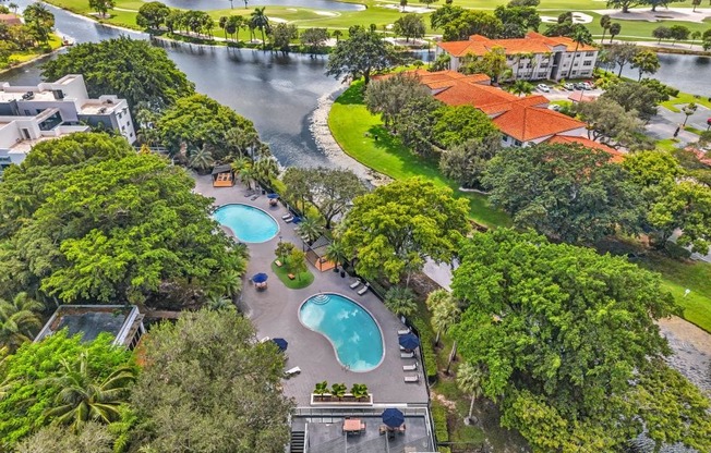 A bird's eye view of a resort with a swimming pool and a river.