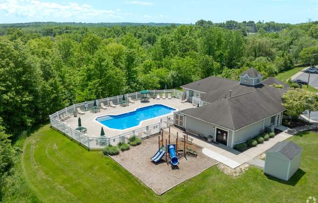 arial view of a pool and a house with a deck and a swimming pool