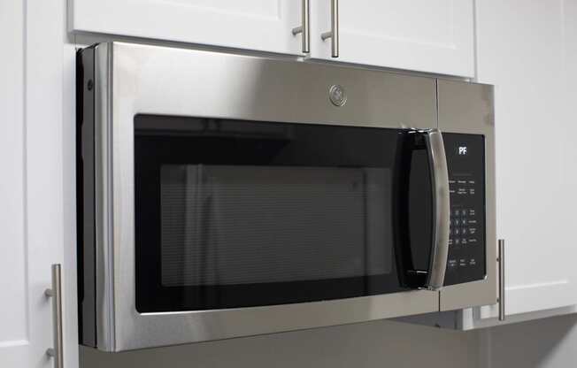 A stainless steel microwave oven with a digital display and control panel.