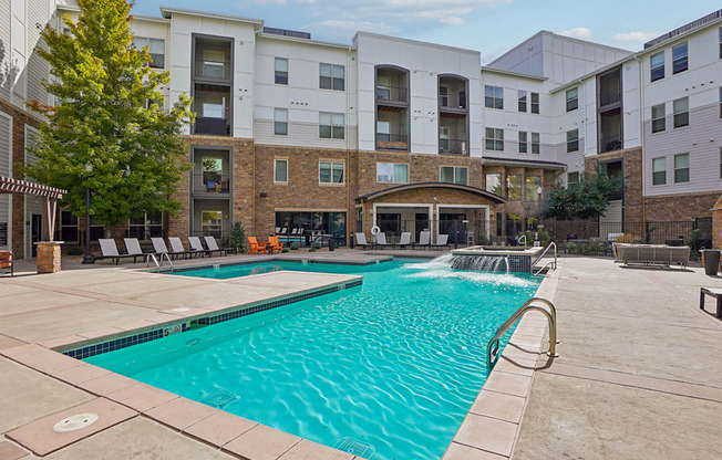 A large swimming pool in front of apartment buildings.