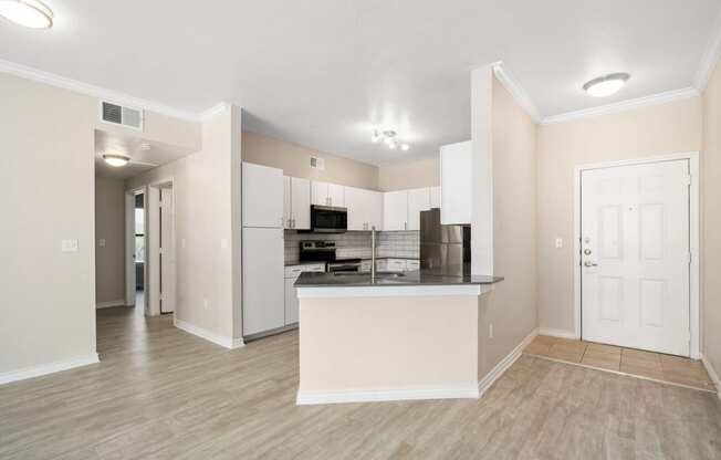 a living room with a kitchen in the background