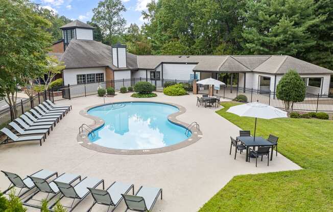 an outdoor pool with chairs and a house in the background at View at Lake Lynn, North Carolina, 27613