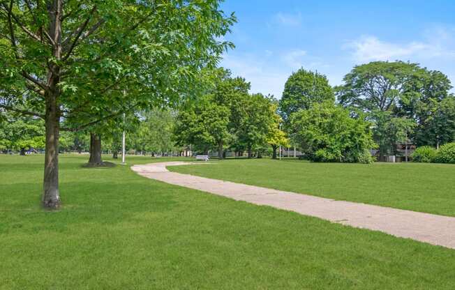 a path through a park with green grass and trees at Lafayette Park Place, Detroit, 48207