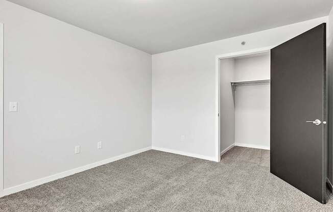 A room with a black door and a white wall.