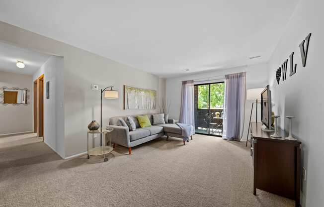 Cozy living room with natural light at Woodland Villa Apartments in Westland, MI.