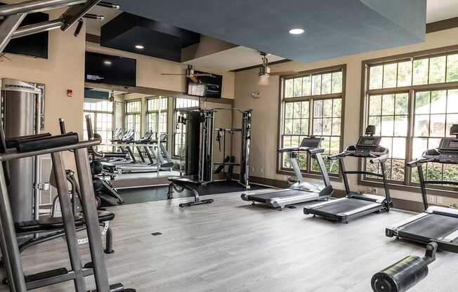 A gym with treadmills, weights, and exercise equipment.