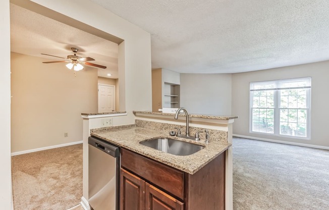 an empty kitchen with a sink and a ceiling fan