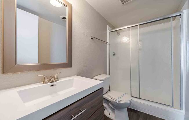 A bathroom with a toilet, sink, and shower.