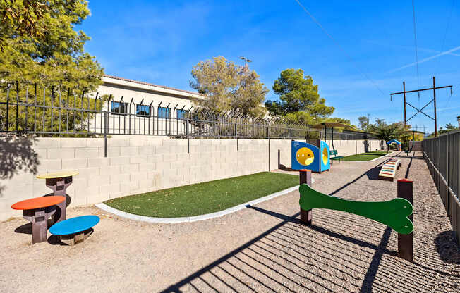 A playground with a green slide and a blue and yellow play structure.