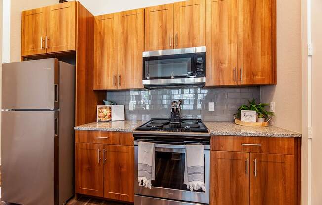 A kitchen with wooden cabinets and a stainless steel refrigerator.