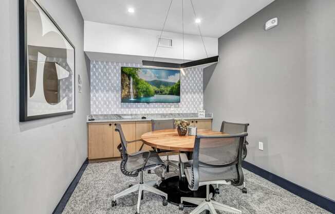 a conference room with a table and chairs and a tv on the wall