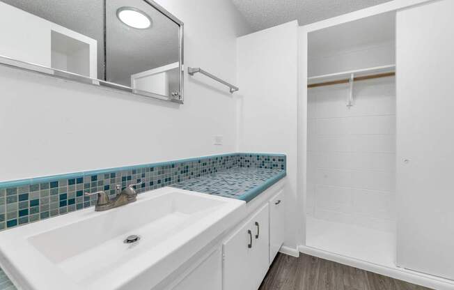 A white bathroom with a sink and a mirror at The Phoenix Apartments on 6th Avenue, Arizona 85013