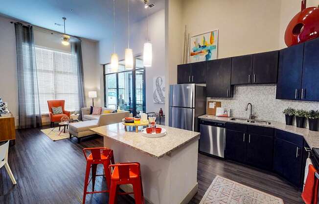 Kitchen with a white countertop and black cabinets at Civic at Frisco Square Apartments, Texas