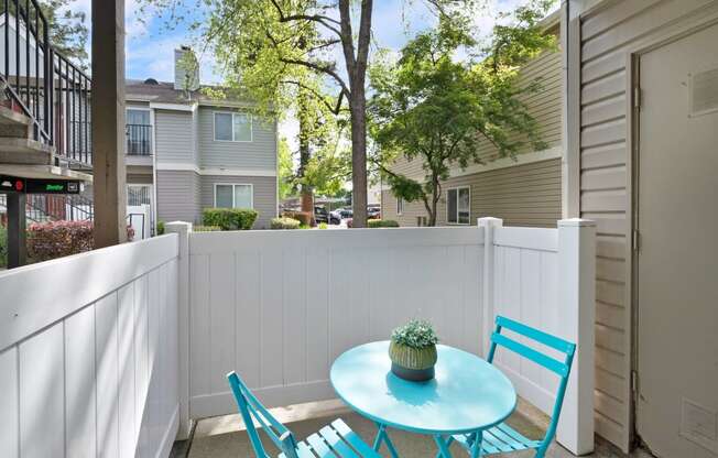 a small patio with blue chairs and a blue table