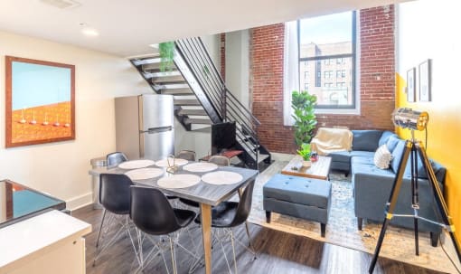 a living room with a dining room table and a refrigerator