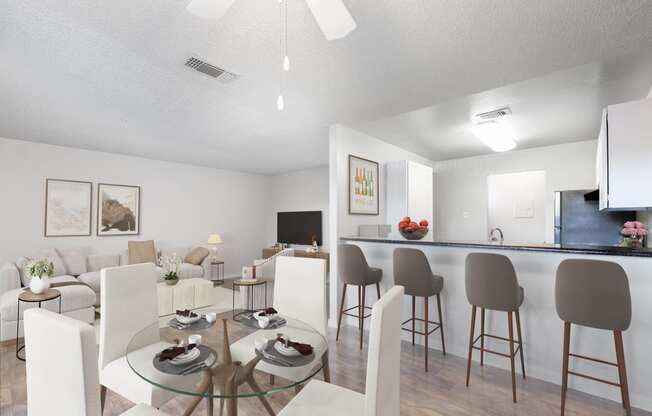 a living room and dining room with a glass table and chairs