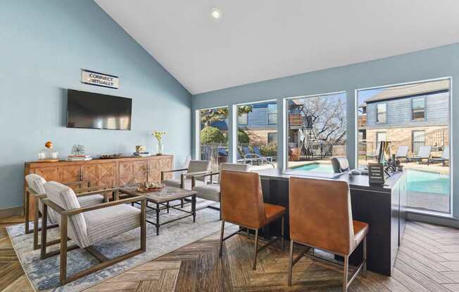 A living room with a pool outside the window.