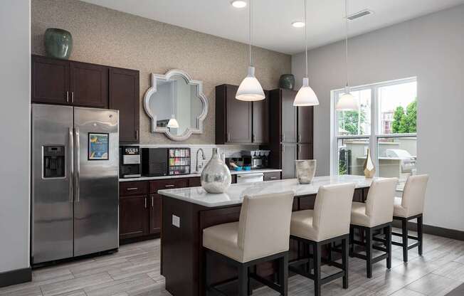 A modern kitchen with a large island and chairs.