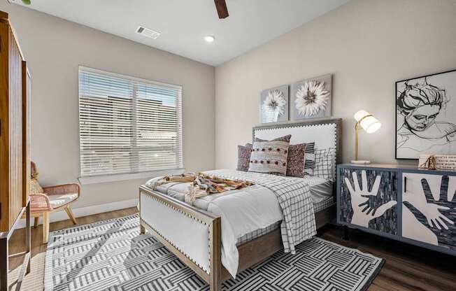 A bedroom with a bed, a chair, and a ceiling fan.