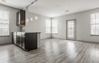 the living room and kitchen of an empty house with a large window