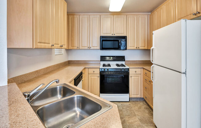 a kitchen with a sink stove refrigerator and microwave  at Falcon Bridge at Gale Ranch, San Ramon, CA