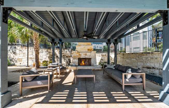 a patio with couches and tables and a fireplace