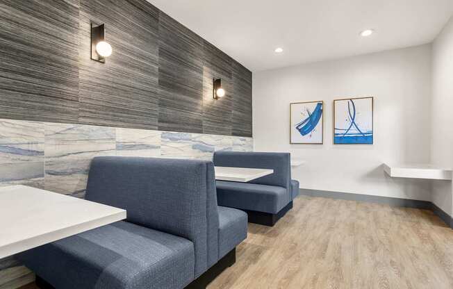 A modern waiting room with blue chairs and a wooden wall.