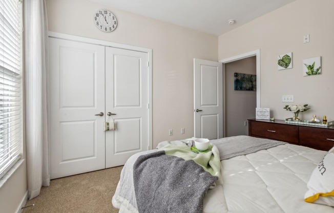 a bedroom with a bed and a dresser and a clock