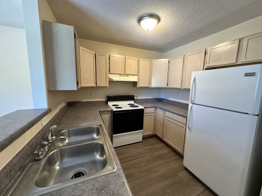 an empty kitchen with a sink and refrigerator