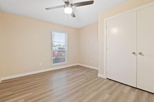 an empty room with a ceiling fan and a door