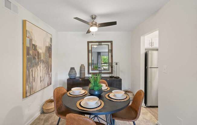 A dining room with a round table set for two.